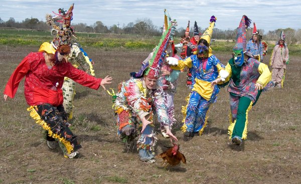 Los Mardi Gras persiguiendo un pollo, una de las imágenes habituales del Courir de Mardi Gras Los Mardi Gras persiguiendo un pollo, una de las imágenes habituales del Courir de Mardi Gras